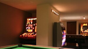 A pool table with balls and a cue stick, surrounded by walls with a slot for a slot machine. - Dutchman Hotel (Blackpool)