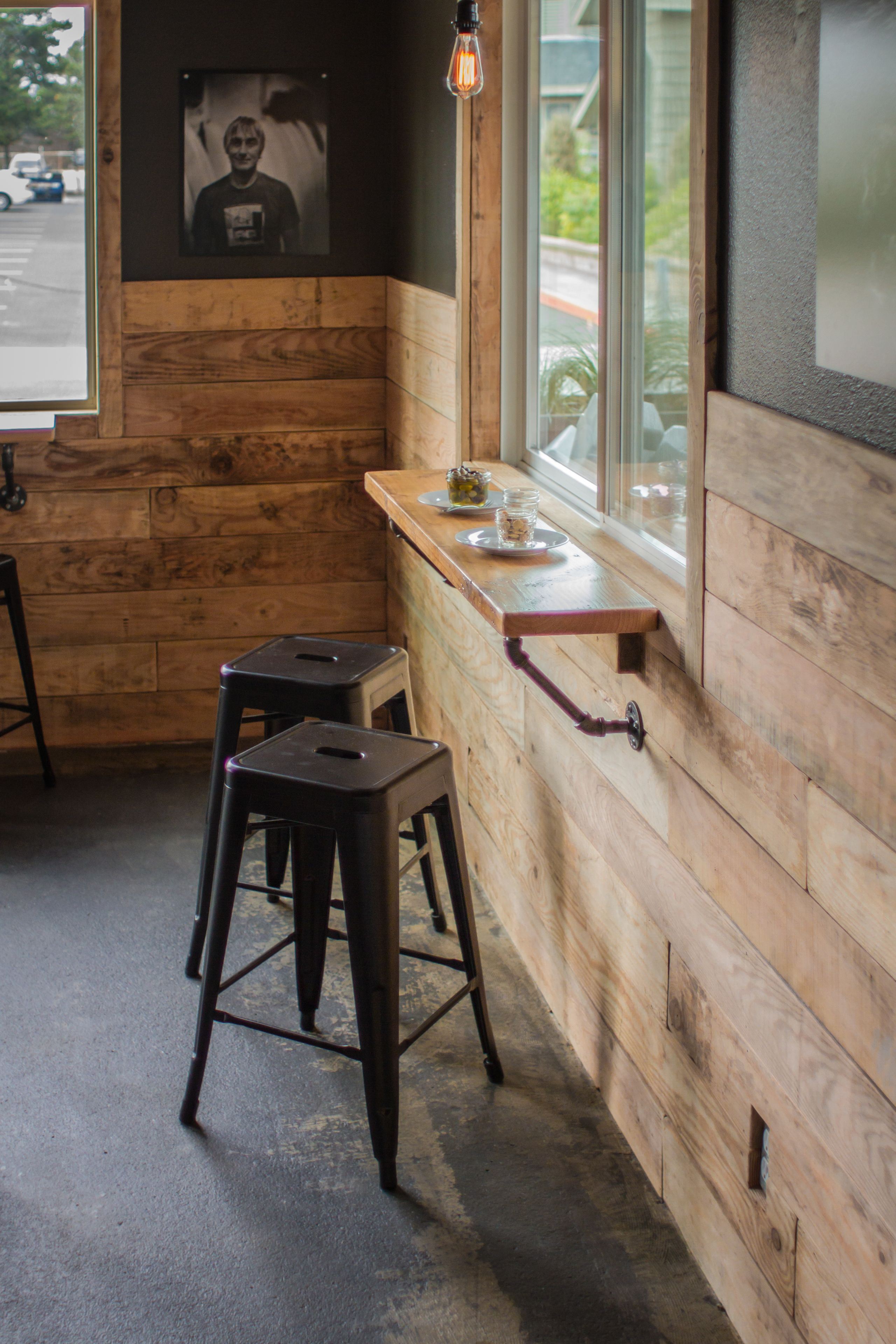 A wooden interior with a bar counter, stools, and a framed picture on the wall.