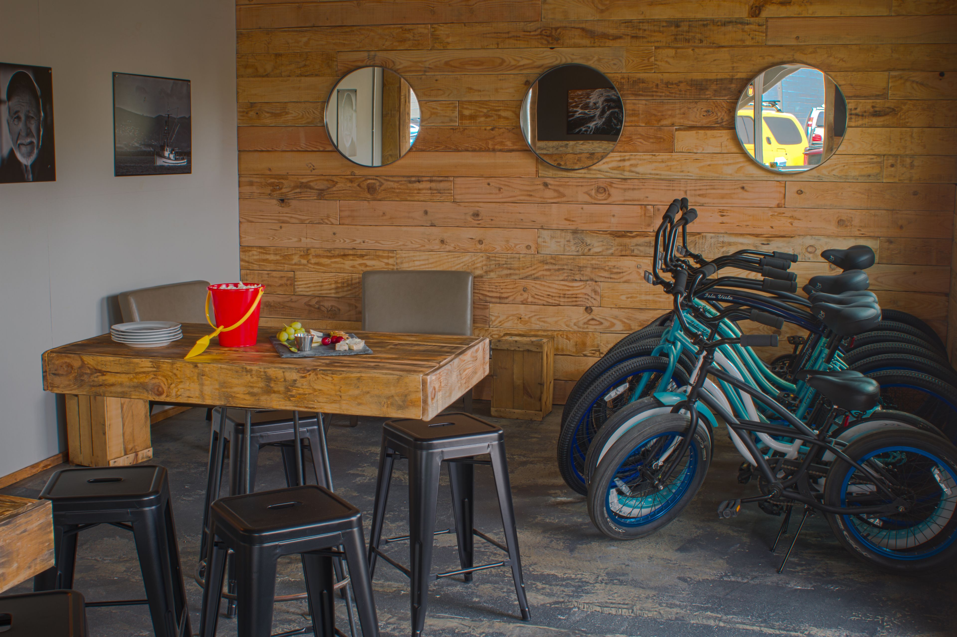 Un interior de fusta amb una taula de dinar, tamborets i una bicicleta.