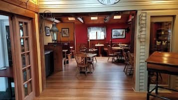 A cozy restaurant with wooden floors, a large clock, and red walls.