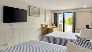 A hotel room with two beds, a TV, a desk, and a balcony with a view. - Harborline Hotel (Rockland)
