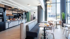 A modern cafe with a counter, seating area, and large windows. - Harborline Hotel (Rockland)