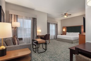 A hotel room with a bed, a desk, a chair, a sofa, and a lamp. - Homewood Suites by Hilton TechRidge Parmer @ I-35 (Austin)