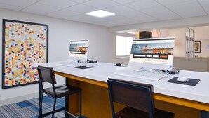 Une salle de conférence avec une longue table, deux chaises et un grand écran affichant une page web.