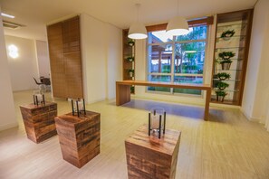 Um interior moderno com móveis de madeira, uma janela ampla com vista e uma prateleira com plantas.