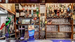 A bar area with a variety of liquor bottles and a Guinness tap. - Thistle Dhu Guest House (Blackpool)