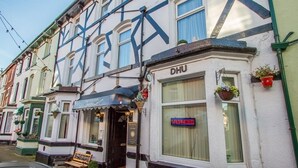 A traditional building with a sign reading "DHU" and a neon sign "VACANCIES" on the window. - Thistle Dhu Guest House (Blackpool)