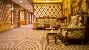 A luxurious room with ornate furniture, a patterned carpet, and a decorative wall.