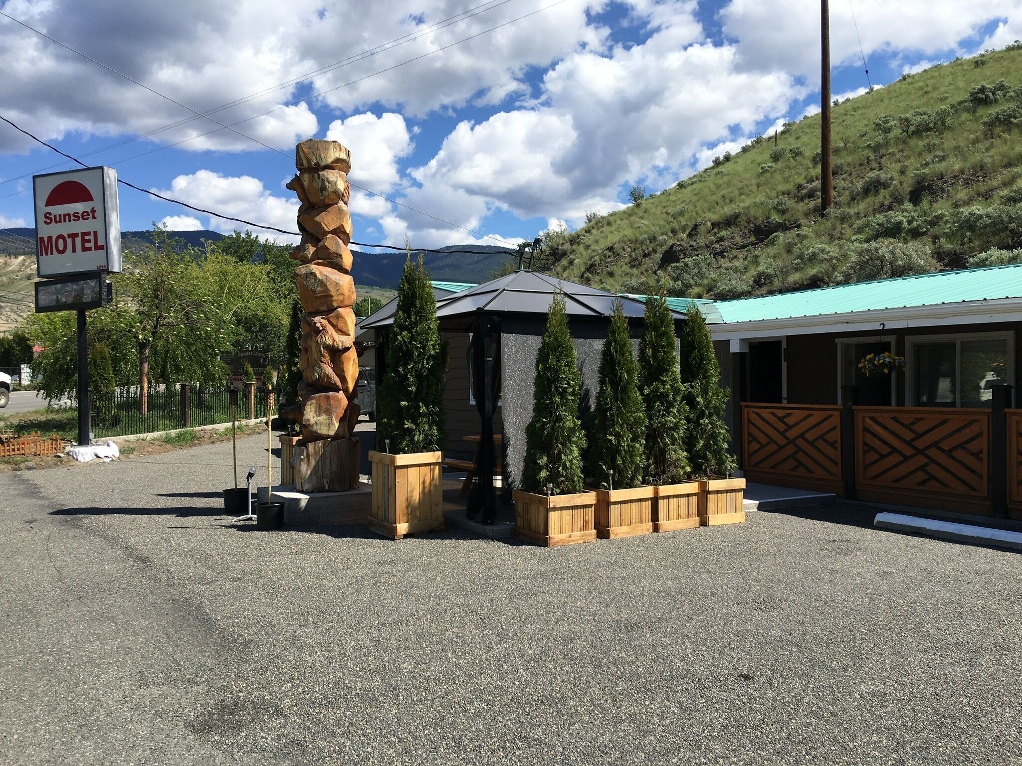 A Sunset Motel with a distinctive rock sculpture and a small building with a blue roof.