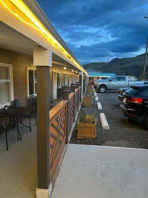 A motel with outdoor seating and a parking area.