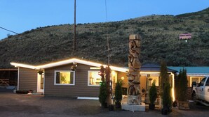 A motel with a simple, modern design, featuring a well-lit entrance and a signboard for the Sunset Motel. - Sunset Motel (Cache Creek)