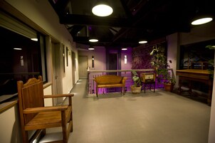 Un couloir avec un banc en bois, une plante en pot et une table en bois.