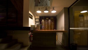 A reception area with a reception desk, a fire extinguisher, a coat rack, and a set of lockers.