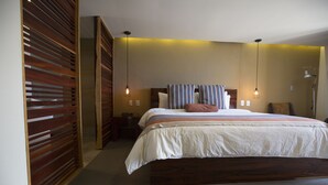 A bedroom with a large bed, wooden headboard, and a bedside table.