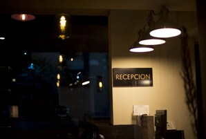 Ein Empfangsbereich mit einem Schild mit der Aufschrift 'RECEPTION' und einem Schreibtisch mit Computer und Telefon.
