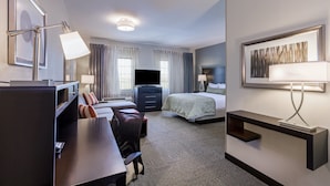 A hotel room with a desk, chair, bed, TV, and a large painting on the wall. - Staybridge Suites Fort Worth - Fossil Creek by IHG (Fort Worth)
