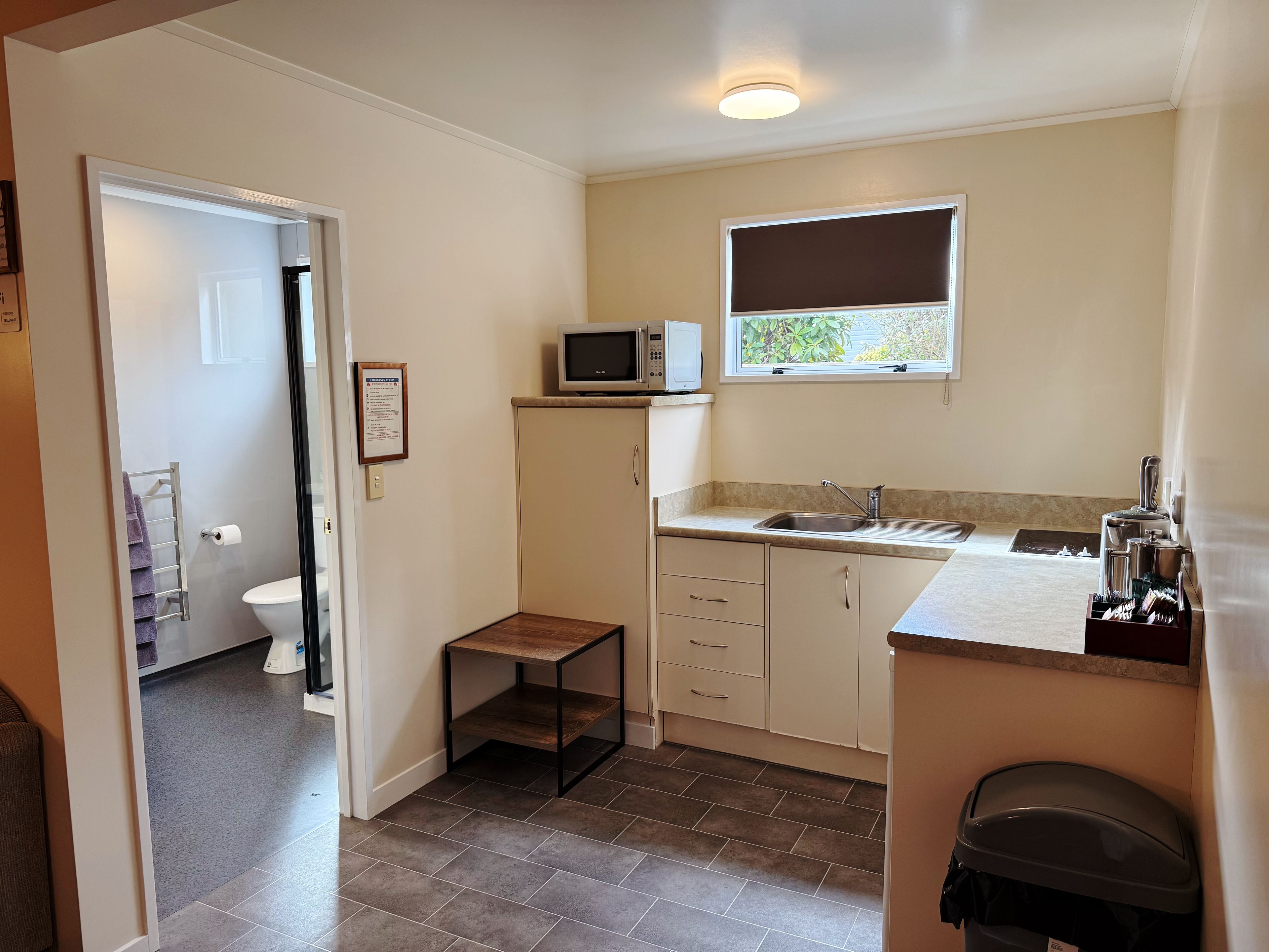 A compact kitchen with a microwave, sink, and a small table.