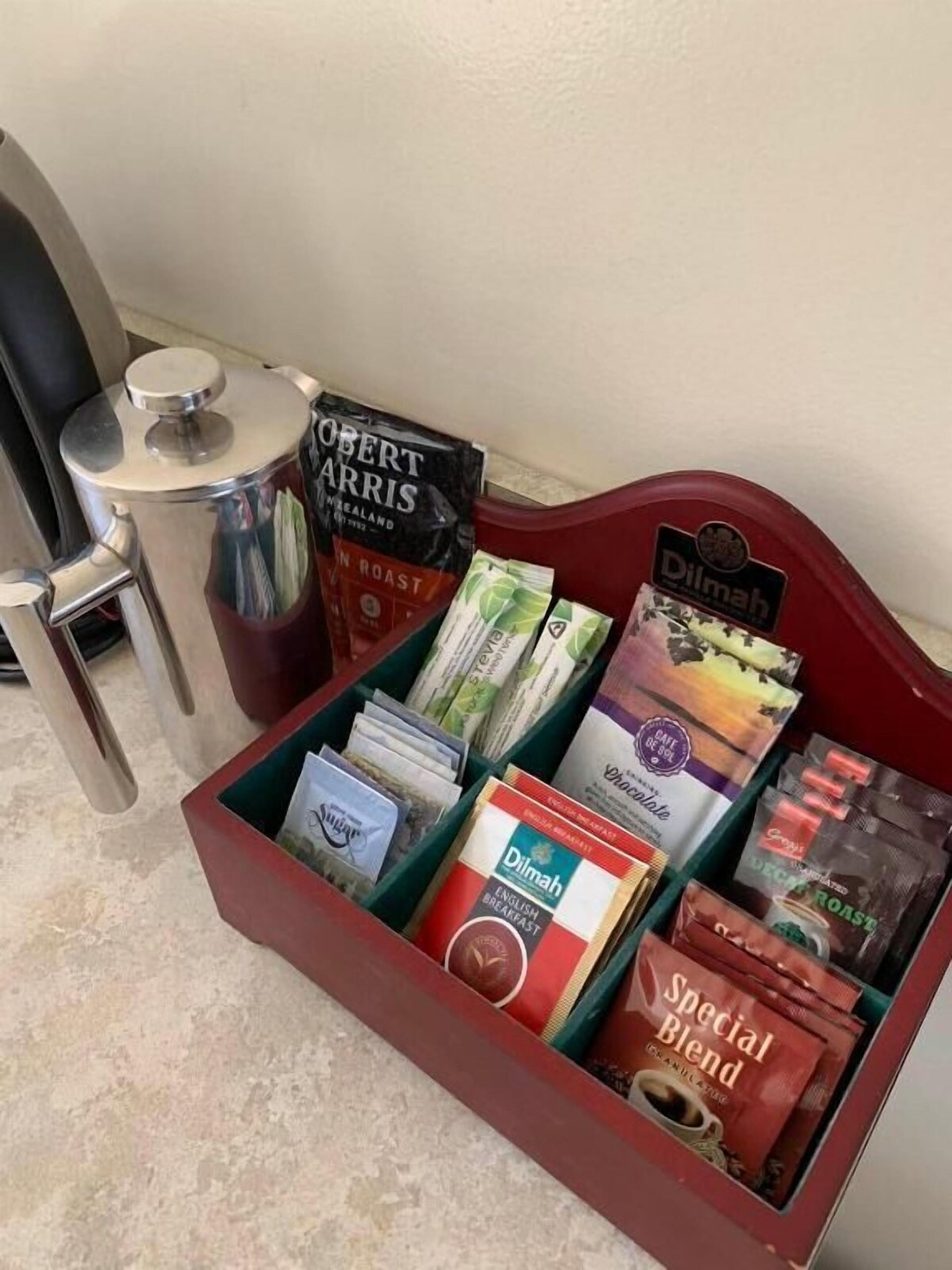 A coffee station with various brands of coffee and tea, including 'Robert Harris Roast' and 'Dilmah'.