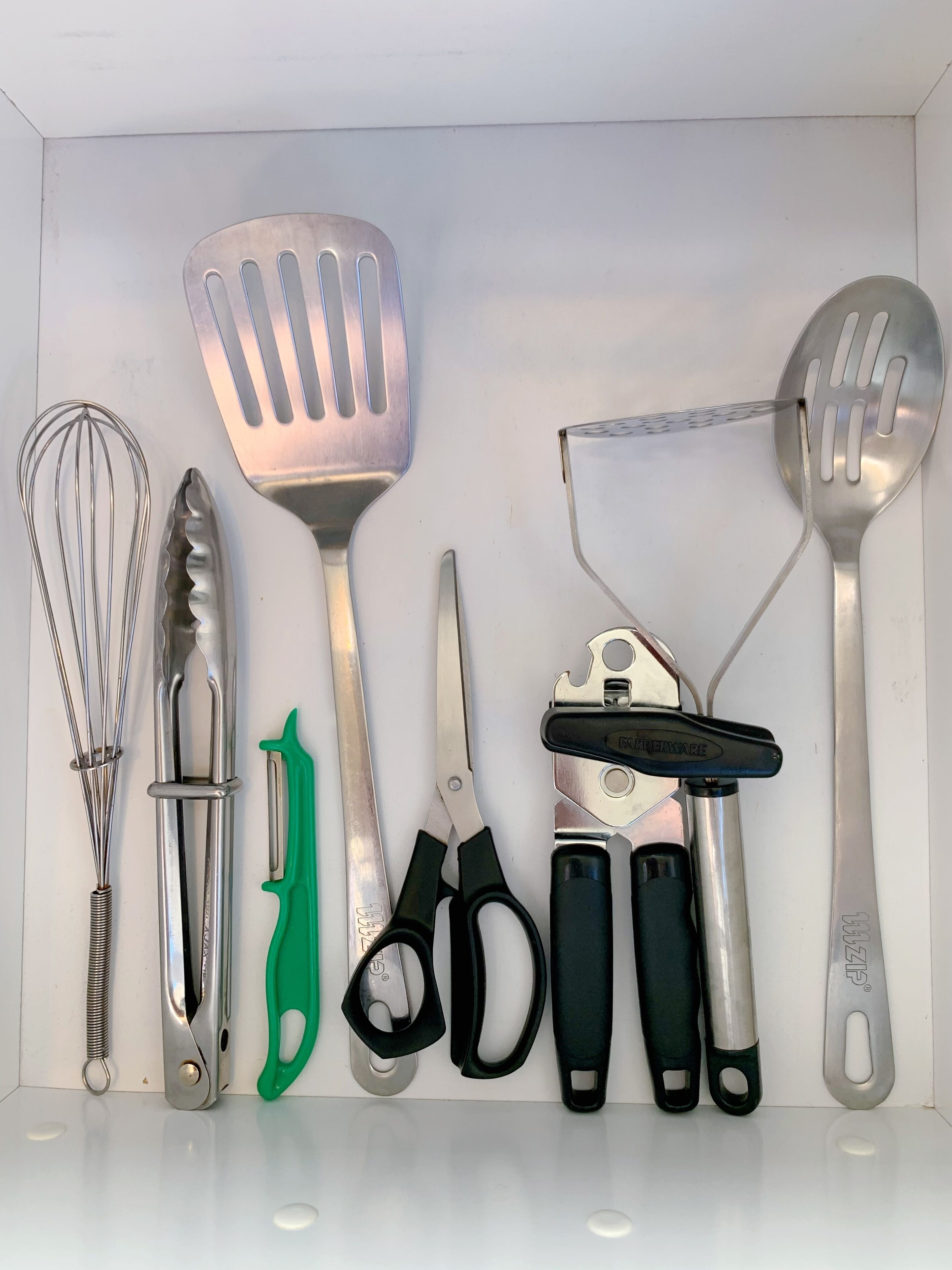 A collection of kitchen utensils including a whisk, spatula, and scissors.
