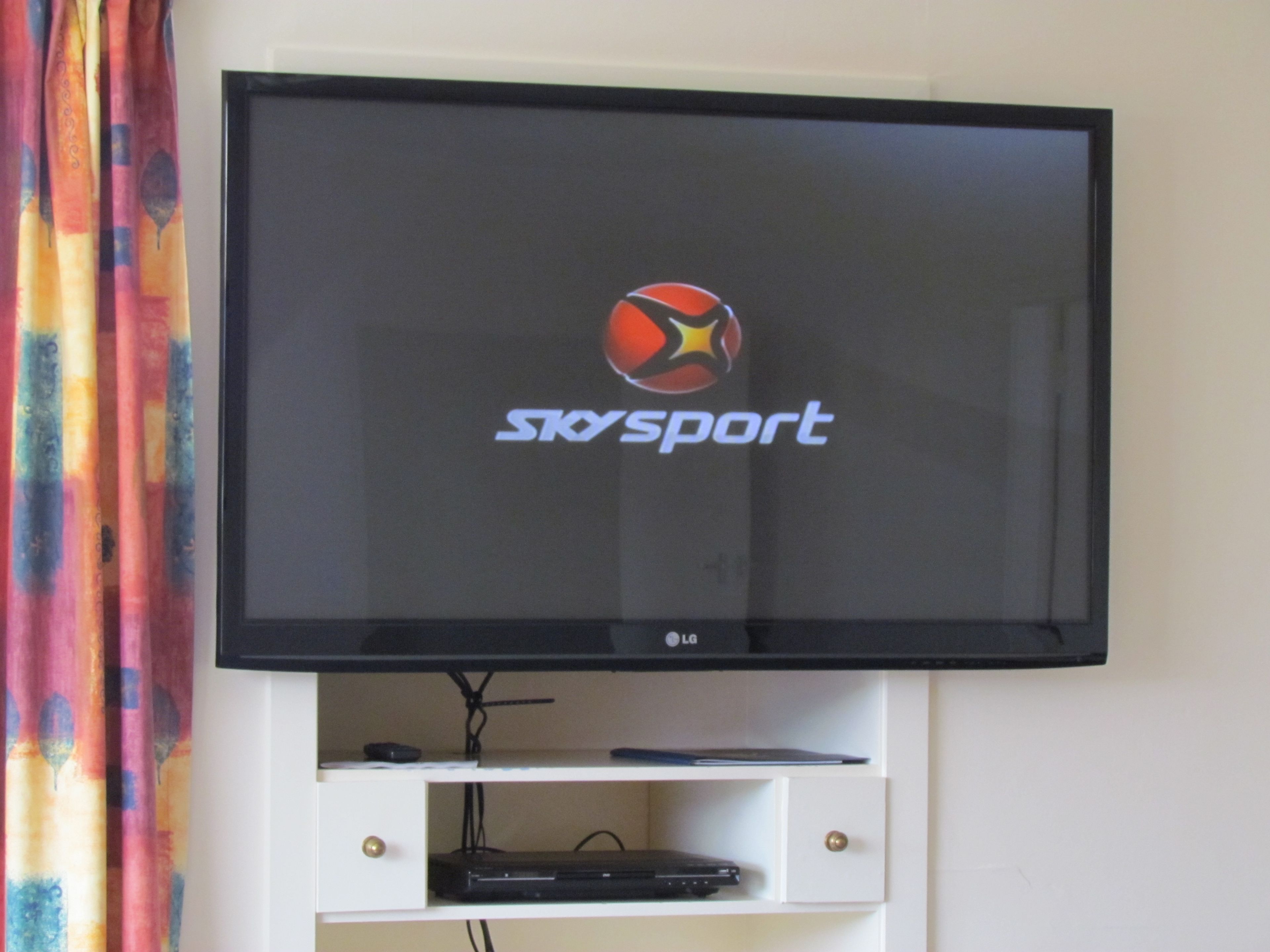 A flat-screen TV mounted on a wall with the logo 'SkySport' and 'LG' branding.