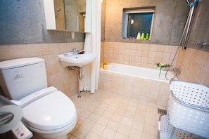 A bathroom with a toilet, sink, and bathtub. - Full Circle (Kutchan)