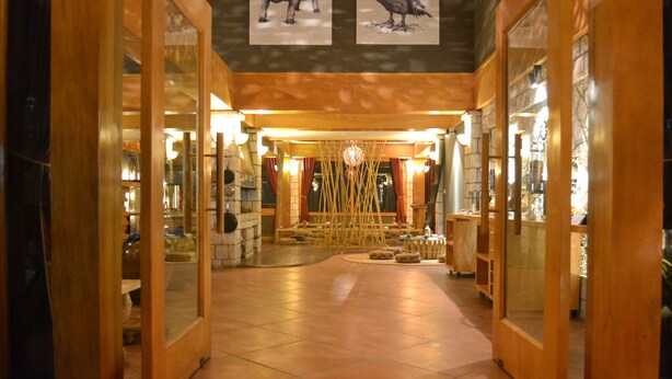 A corridor with wooden doors and a tiled floor, leading to a room with a wooden ceiling and a hanging light fixture. - The Hill Station Boutique Hotel (Sa Pa)
