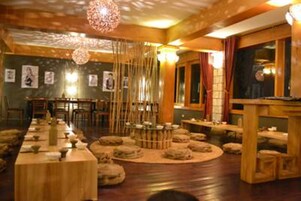 A traditional Japanese-style room with tatami mats, low tables, and a central tatami mat arrangement.