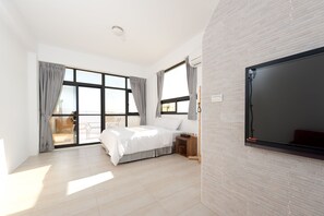A modern bedroom with a large bed, a TV, and a sliding glass door leading to a balcony. - Discovery Secret Resort (Linbian)