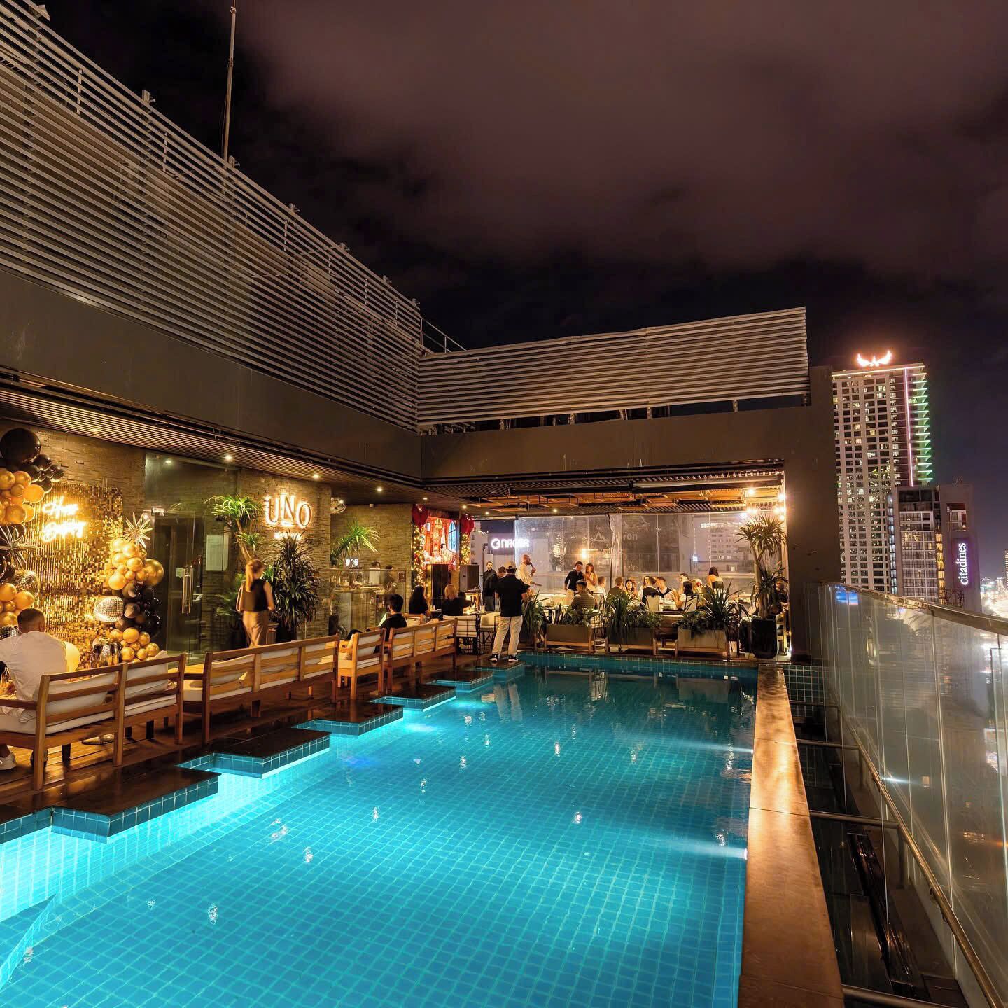 An indoor swimming pool with a bar area and seating.