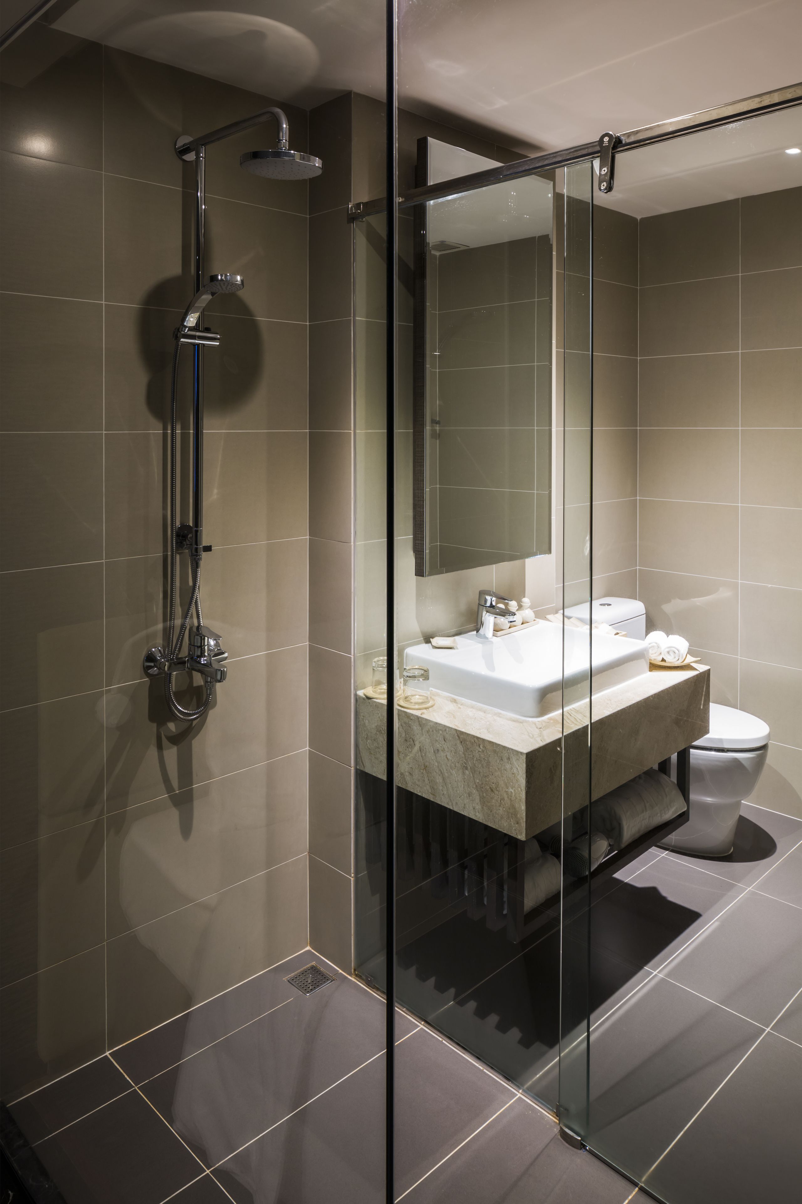 Un bagno moderno con doccia vetrata, lavabo in marmo e water.