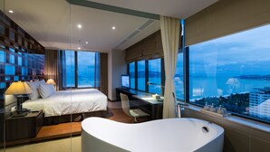 Een moderne hotelkamer met een groot bed, een bureau, een computer en een bad.