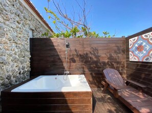 A wooden deck with a hot tub and a lounge chair. - Murraya Paniculata Villa (Magong)