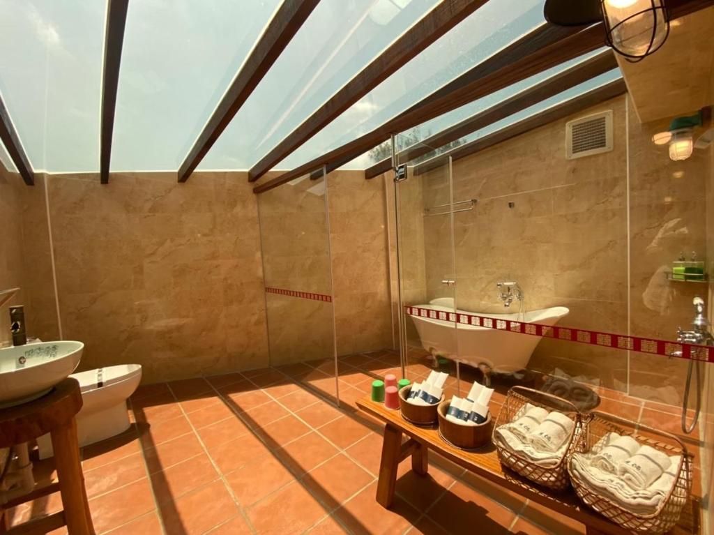 A modern bathroom with a glass-enclosed shower, a freestanding bathtub, and a vanity with a bowl sink.