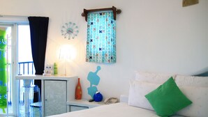 Une chambre d’hôtel avec un lit, un bureau avec une lampe, un téléphone et une fenêtre avec des rideaux.