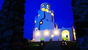Un bâtiment au design unique, doté d’une tour imposante et de nombreuses fenêtres illuminées.