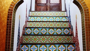 A staircase with colorful, patterned tiles leading to a door with a decorative lattice. - Raid Gardden Boutique Hotel (Magong)
