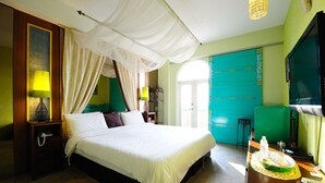 A neatly made bed with a canopy, a bedside table with a lamp, and a tray with a bottle and a glass on the nightstand. - Raid Gardden Boutique Hotel (Magong)