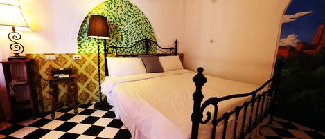 A room with a checkered floor, a bed with a metal frame, a lamp, a wall-mounted air conditioner, and a decorative archway with a green mosaic pattern.