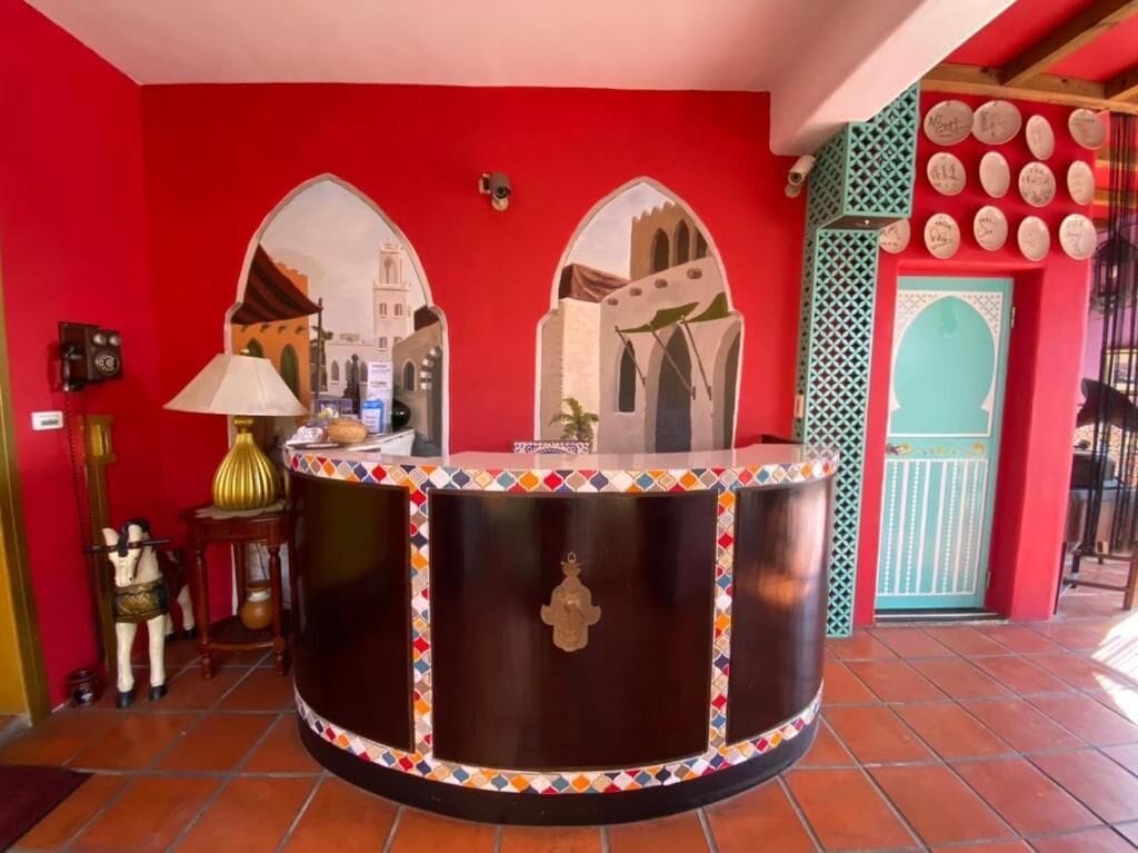 A reception area with a curved counter, two arch-shaped windows, and a decorative wall with plates.