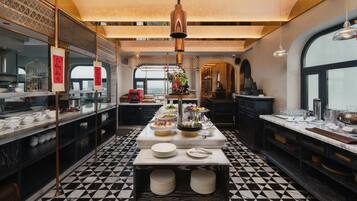 A modern kitchen with a black and white checkered floor, a central island with dishes, and hanging pendant lights.