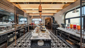 Una cocina moderna con suelo a cuadros, encimeras de mármol y una isla central con una presentación escalonada de alimentos.