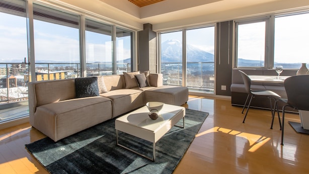A modern living room with a sofa, coffee table, and dining area.