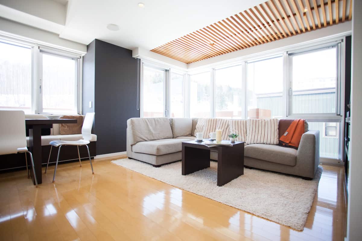 A modern living room with a sofa, coffee table, and a dining area with a chair and table.