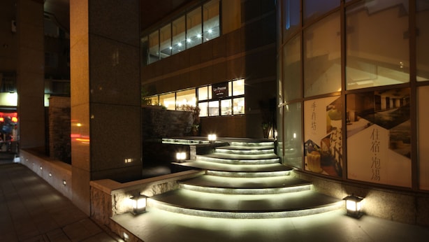 A nighttime view of a building with illuminated steps leading to a restaurant entrance.
