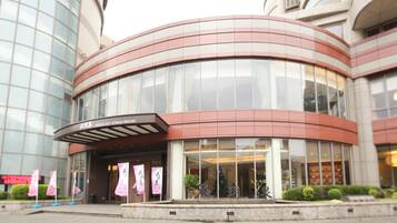 A hotel with a curved facade, large glass windows, and a sign indicating it is a hot spring resort.