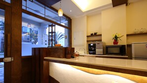 A modern kitchen with a wooden counter, a microwave, a refrigerator, and a window with a view of the outside. - Hualien Little Squirrel B&b (Hualien City)