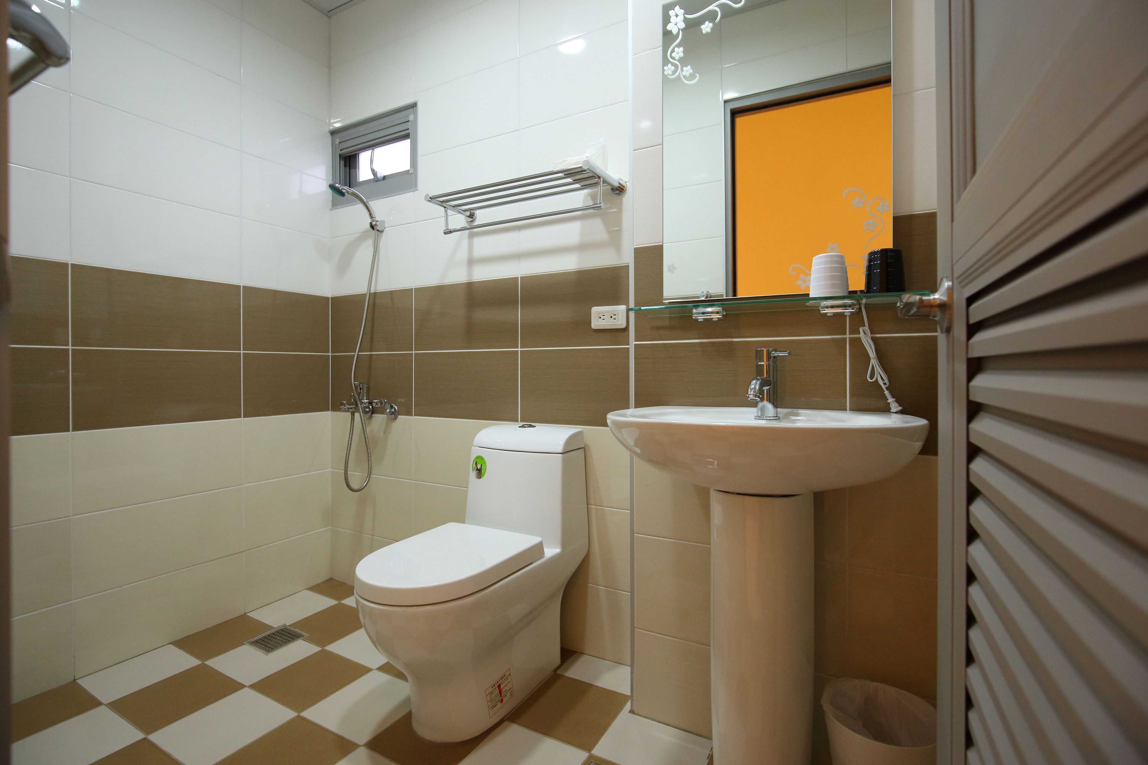 A bathroom with a toilet, sink, and shower.