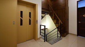 A staircase with a wooden handrail and a carpeted landing. - Hualien Little Squirrel B&b (Hualien City)