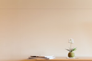 A minimalist desk with a small plant and some documents. - Kamakura (Kutchan)