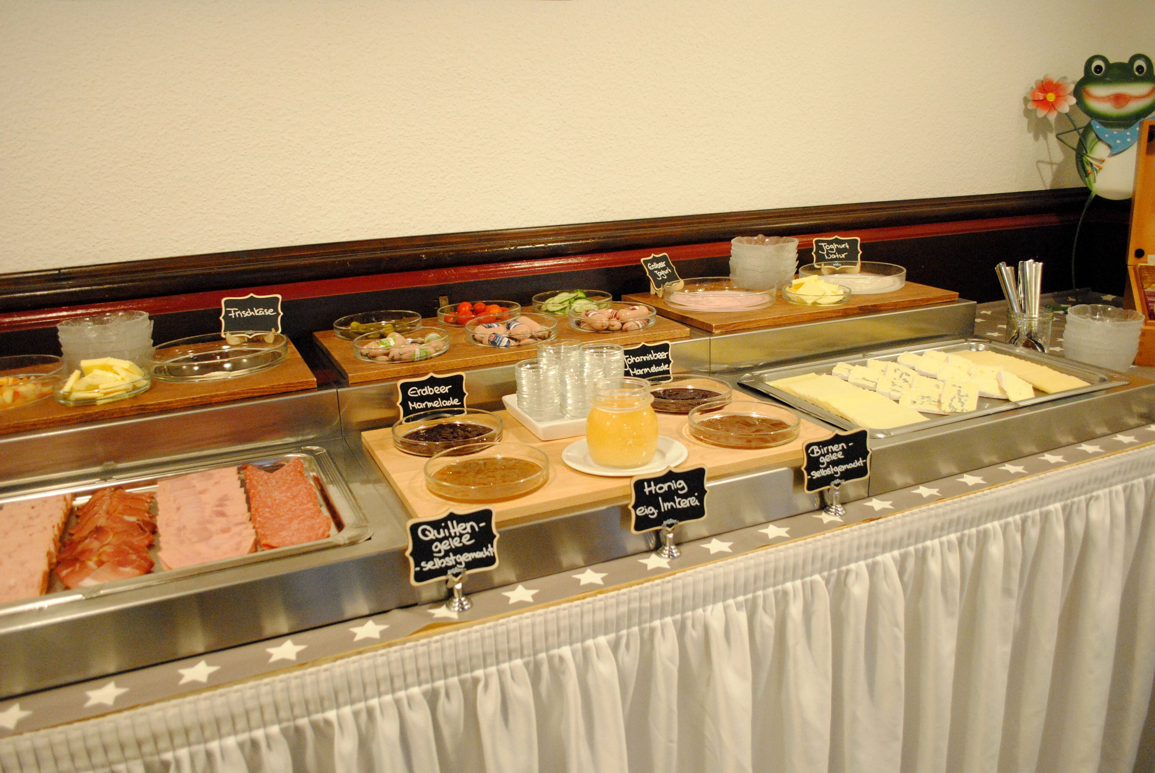 A buffet with various food options including meats, cheeses, and salads.